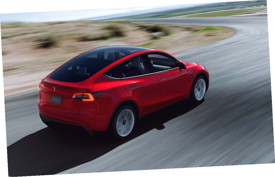 Röd Tesla fotograferad på landsväg med fartoskärpa, fotograferad snett uppifrån bakifrån.