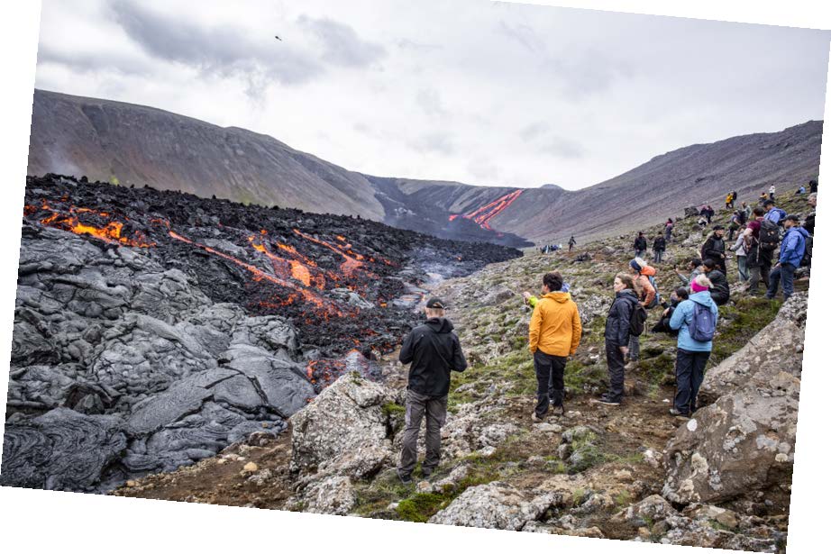 Bild på rykande lavafält, i förgrunden en grupp människor som tittar på.