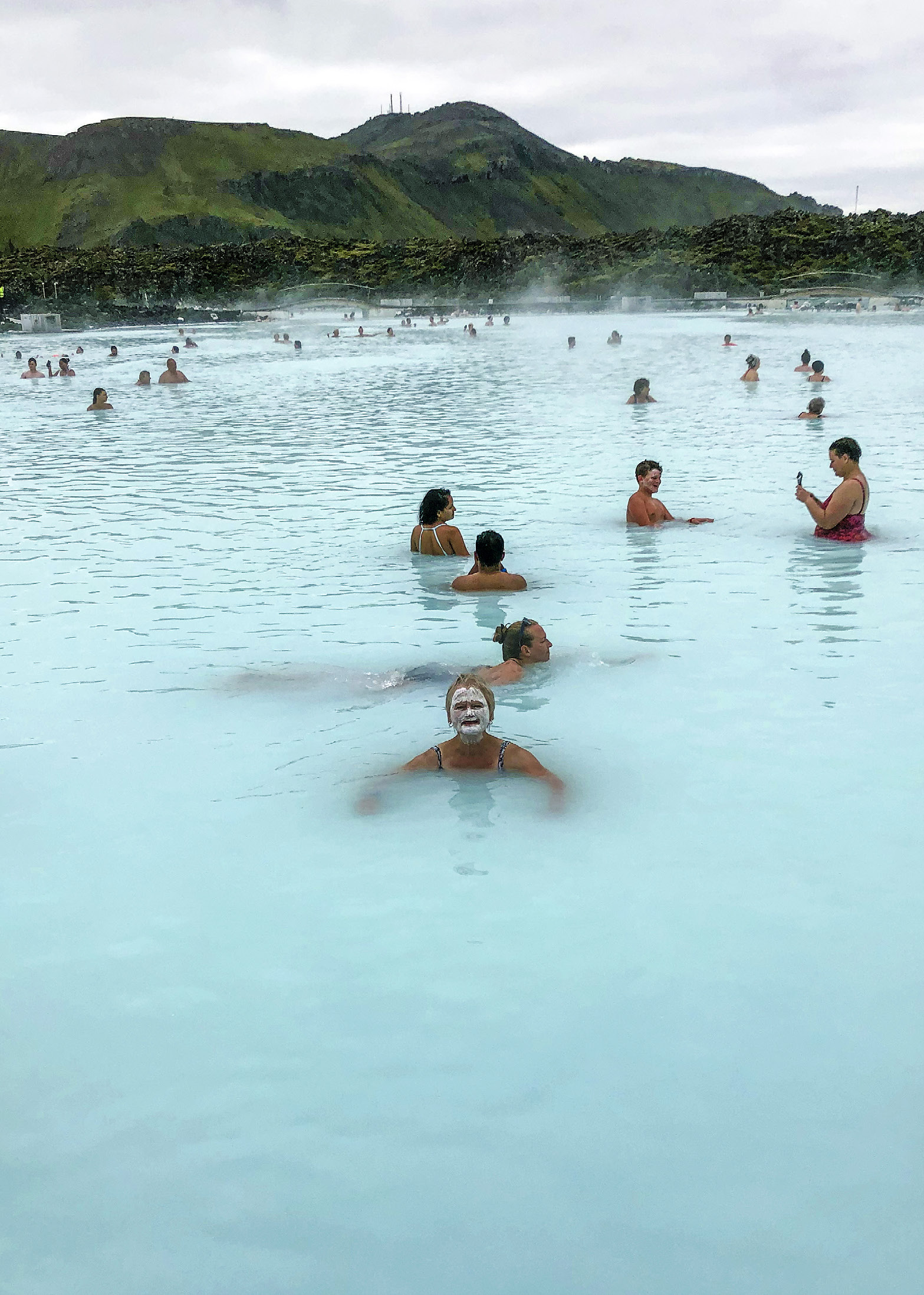 Människor som badar i ljusblått grumligt vatten.